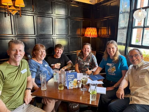 Six smiling members of Wokingham Energy Collective sitting around a table at the first meet-up